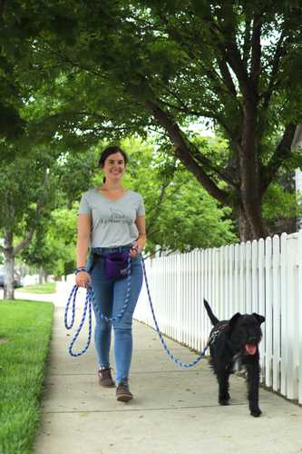 Woman walking a dog on a loose leash