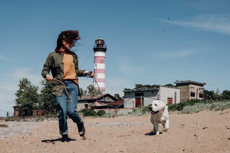 Woman runs with dog on long leash